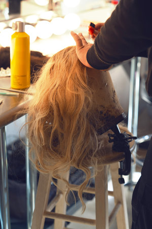 Hairdresser combing long blonde hairの写真素材