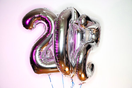 Number 20 gold and silver foil balloon on white background. Anniversary celebration.の写真素材