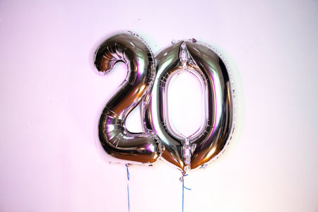 20th anniversary foil balloon in the form of number twenty on a white backgroundの写真素材