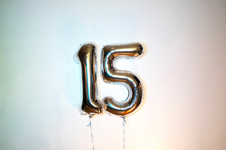 Number 15 gold foil balloon on a white background. Birthday decoration.の写真素材