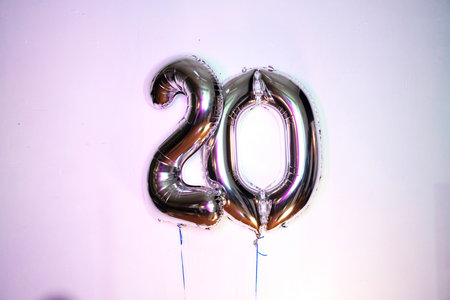 Number 20 gold foil balloon on a white background. Anniversary celebration.の写真素材