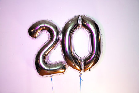 20th birthday gold foil balloon number and text on white background.の写真素材