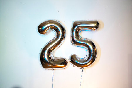 Number 25 gold foil balloon on a white background, closeup of photoの写真素材