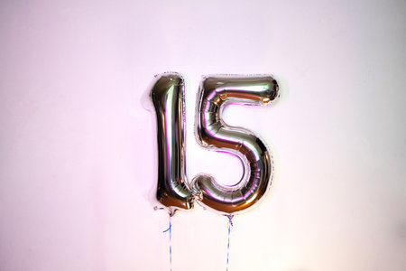 Number 15 gold foil balloon on white background. Birthday or anniversary celebration.の写真素材