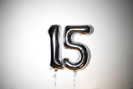 Silver foil balloon number 15 on a white background. Birthday or anniversary celebration.の写真素材