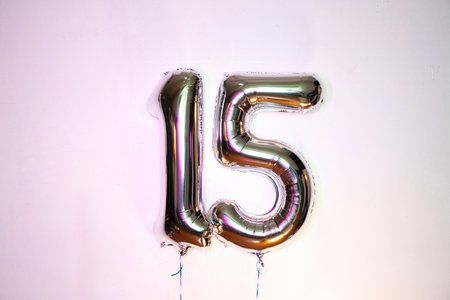 Number 15 gold foil balloon on white background. Number fifty five.の写真素材