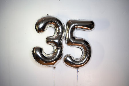 Number 35 gold foil balloon on a white background. Birthday or anniversary celebration.の写真素材