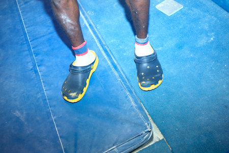 Low section of african american male athlete standing on ring