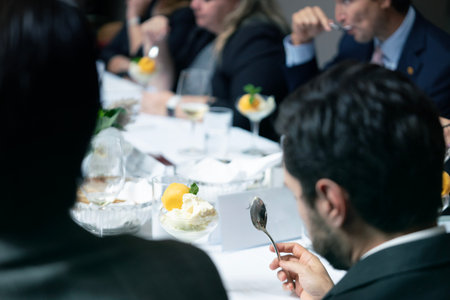 selective focus of businesspeople eating ice cream at table in restaurantの写真素材