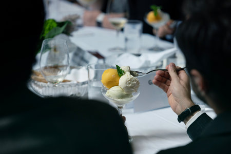 Man eating ice cream in a restaurant, close-up of handsの写真素材