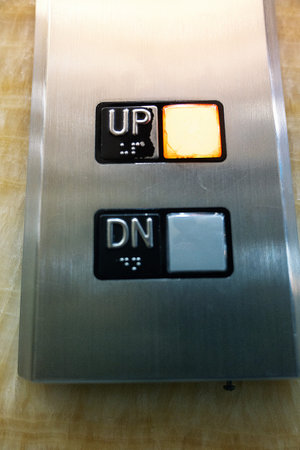 Close-up view of an elevator button with the word up and down