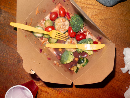 Vegetable salad in a cardboard box with a fork and knife
