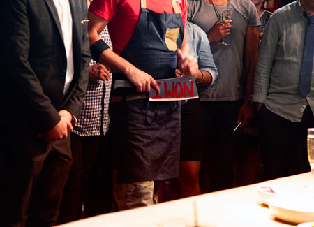 Close up photo of a group of people in a restaurant holding a placard.