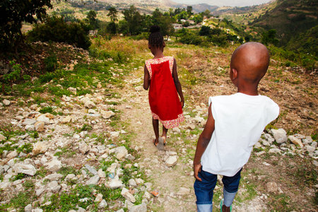 Rear view of a boy and a girl walking on the hillの写真素材