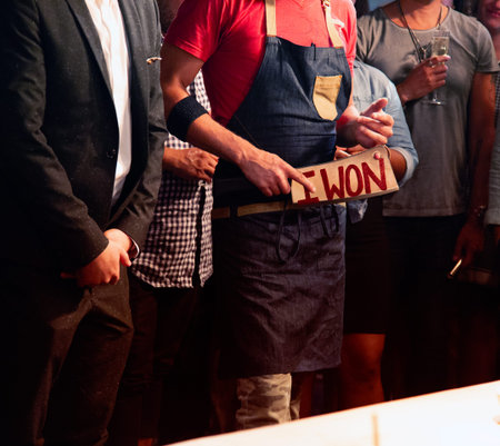 Hands of a barman holding a sign