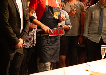 Barman holding a sign in front of a crowd