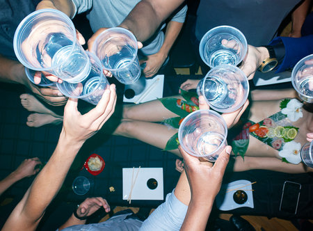 Group of friends toasting in a nightclub. Top view of young people having fun together.の写真素材