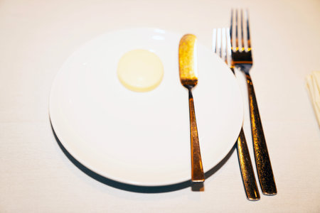 Empty plate and cutlery on white background, selective focus.