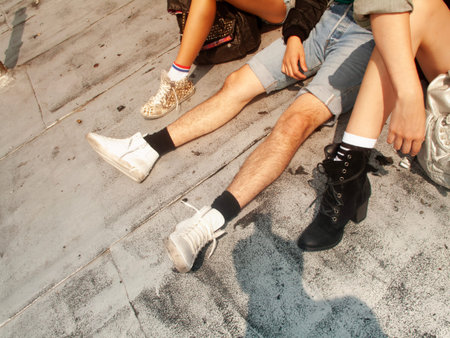 Young couple sitting on the floor in the street, closeup of photo