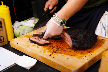 chef cutting a piece of beef on a wooden board in a restaurant