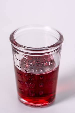 a glass filled with red medicineの写真素材