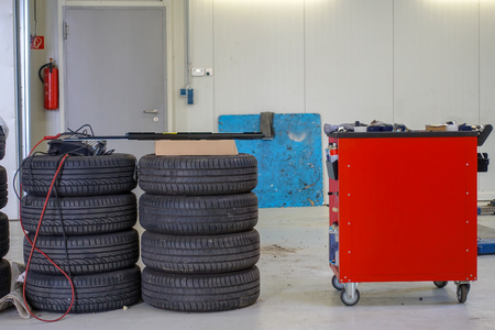 two stacks of car tires and a tool trolleyの写真素材