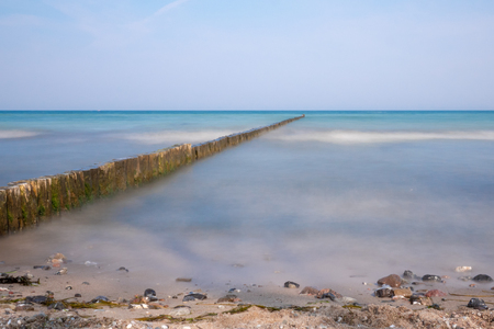 long groynes protrude into the water of the blue Baltic Seaの写真素材