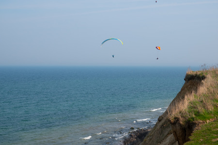 some paragliders fly along the steep coast of the Baltic Seaの写真素材