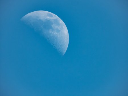 a crescent moon with clear visibility reveals many craters on the surfaceの写真素材