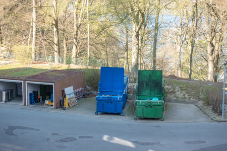 two garbage compactors are standing in the courtyard of a hospitalの写真素材