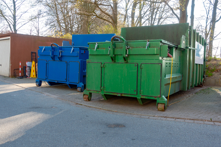 two garbage compactors are standing in the courtyard of a hospitalの写真素材