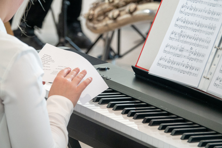 a young pianist studies the schedule before a performanceの写真素材