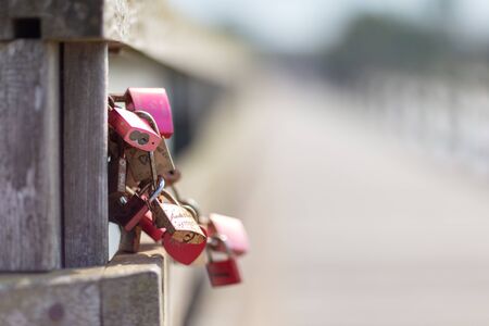 engraved padlocks hanging on a bridge as a symbol for loversの写真素材