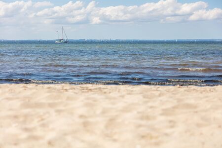 a panoramic view of the beach of the Baltic Sea with a sailing ship on the horizonの写真素材