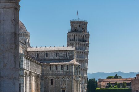 the Leaning Tower of Pisa and the Cathedral of Pisa in front of a bright blue skyの写真素材