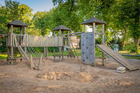 a wooden climbing frame stands on the premises of a kindergartenの写真素材