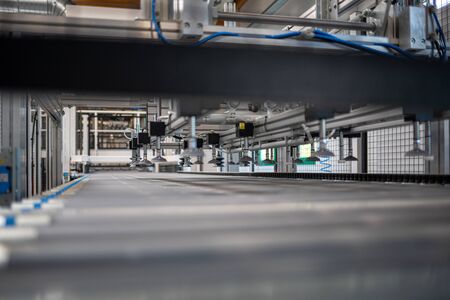 in a factory hall there is a gigantic machine which is equipped by a robot arm