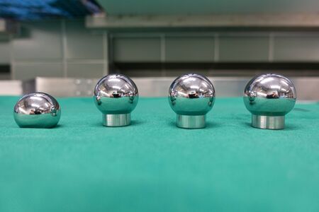 an explanted femoral prosthesis lies on a green surgical drapeの写真素材