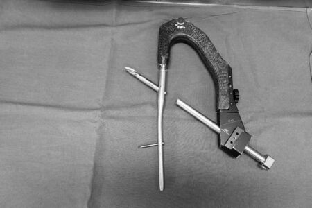 an explanted femoral nail with locking screw lies on a green surgical drapeの写真素材