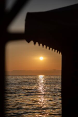 on a beach in the foreground are the waves and in the background is a golden sunsetの写真素材