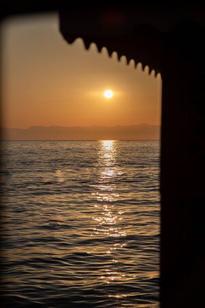 on a beach in the foreground are the waves and in the background is a golden sunsetの写真素材
