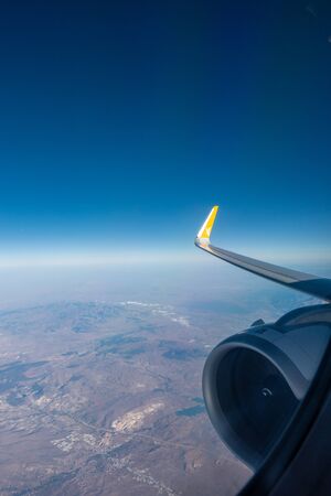 the right wing of the plane rises into the blue skyの写真素材