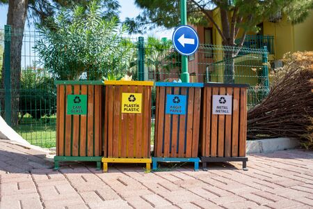 in a street there are different coloured bins to separate the garbageの写真素材