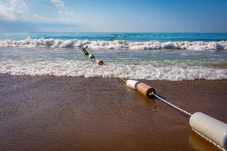 at the beach a barrier line leads into the sea with the best weather and wavesの写真素材