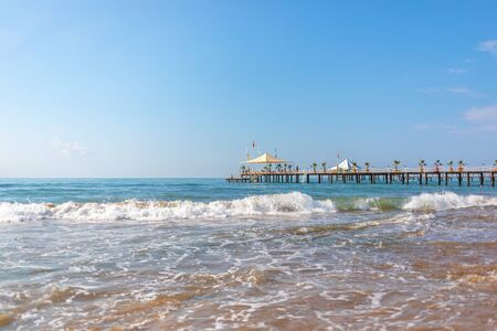 a wooden walkway leads across the blue sea in fine weatherの写真素材