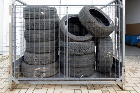 Many old tyres pile up in front of a garage to be disposed .の写真素材