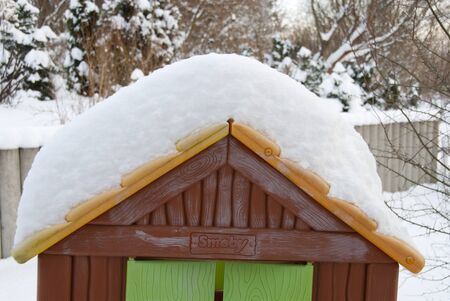 a thick white blanket of snow covers garden furniture standing on a terraceの写真素材