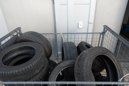 Many old tyres pile up in front of a garage to be disposed of.のeditorial素材