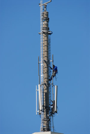 a worker climbs on a mobile phone mastのeditorial素材