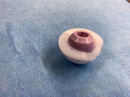a duo head hip prosthesis is placed on a light blue cloth, with the cup made of plastic and the head made of ceramicsの写真素材